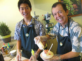 Two men making sushi together in a cheerful kitchen.