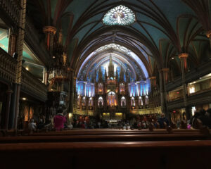 Interior of a grand, illuminated cathedral with intricate architectural details.