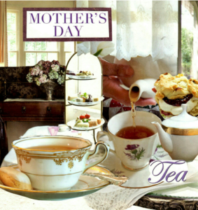 Elegant tea setup celebrating Mother's Day with floral china and desserts.