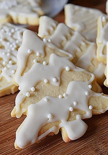 Christmas tree-shaped cookies with white icing and pearl decorations.