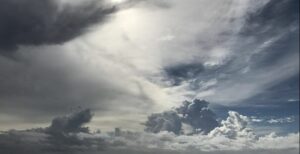 Dramatic sky with thick, textured clouds and patches of sunlight.