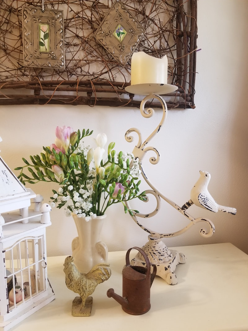 Elegant vintage decor with flowers, a candle, and a bird sculpture.