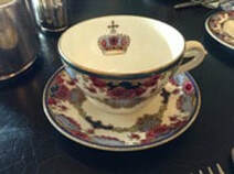 Elegant teacup and saucer with royal crown design.