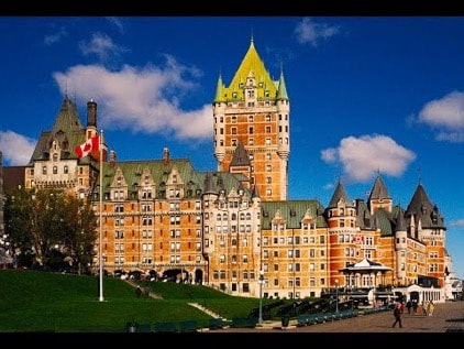 Historic Château Frontenac hotel under a bright blue sky.