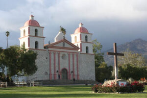 Historic church with twin bell towers under a cloudy sky.