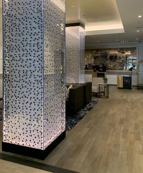 Modern interior with mosaic columns and wooden flooring.