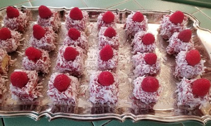 Rows of raspberry-topped coconut dessert squares.