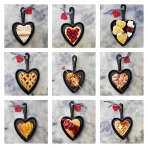 Nine heart-shaped pizzas with various toppings on a gray surface.