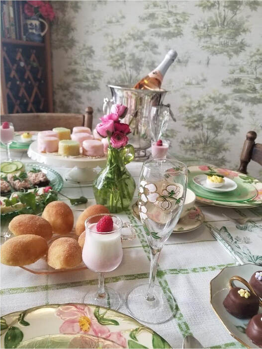 Elegant tea party setup with pastries and floral decor.