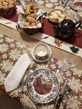 Elegant tea setting with a cup, saucer, and treats on a decorated table.