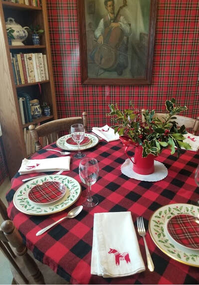 Cozy dining table set with plaid patterns and a festive centerpiece.