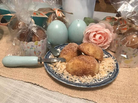 Plate of breaded croquettes on rice with decorative eggs and a flower.