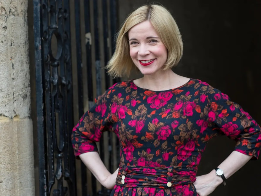 Smiling woman with blonde hair in a floral dress.