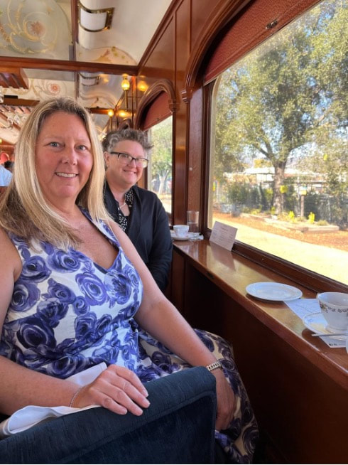 Two women sitting together on a train, enjoying the scenic view.