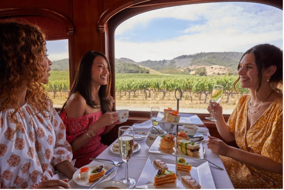 Friends enjoying a meal with vineyard views.
