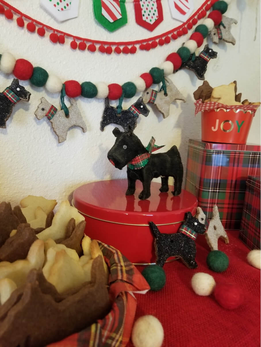 Festive Christmas decorations with two black Scottie dog figurines and cozy teddy bears.