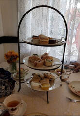 A three-tiered tray with assorted pastries on a table.