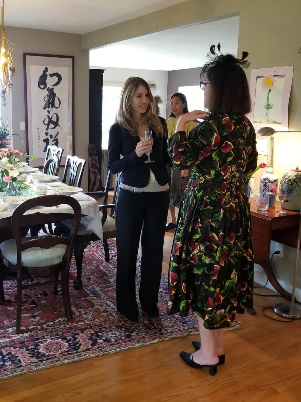 Two women in a cozy, art-filled room having a conversation.
