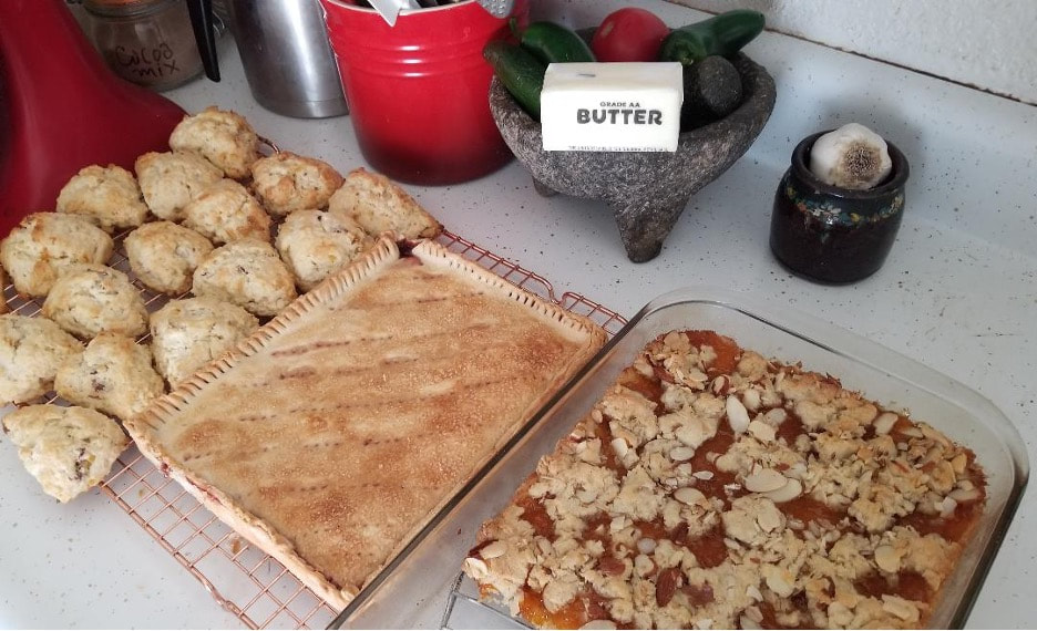 Two types of pastries and a container labeled 'butter' on a kitchen counter.
