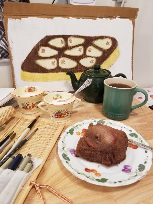 Cozy tea time with chocolate cake and a colorful painting in the background.