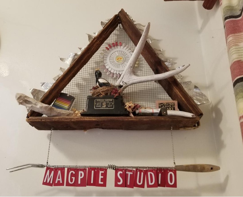 Rustic wooden shelf with clock and decorative items under a triangular frame.
