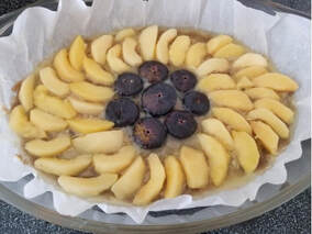 A tart topped with sliced apples and figs.