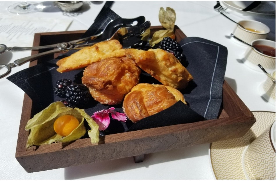 Assorted fried snacks served on a wooden tray with berries and garnishes.