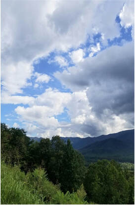 A scenic mountain landscape under a partly cloudy sky.