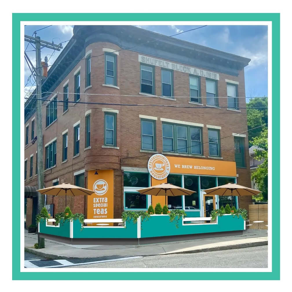 A vibrant coffee shop on a street corner with outdoor seating and a teal fence.