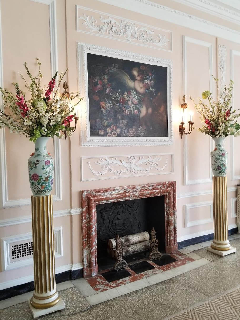 Elegant room with floral arrangements and a classic fireplace.