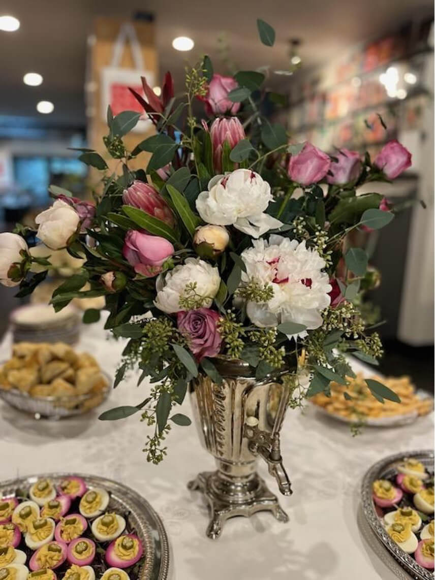 Elegant bouquet of mixed flowers in a silver vase on a festive table.