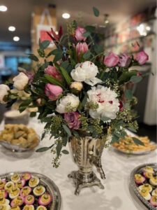 Elegant bouquet of mixed flowers in a silver vase on a festive table.