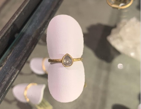 Elegant gold ring with a teardrop-shaped gemstone.