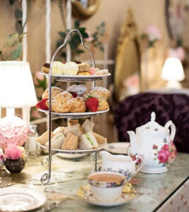 Elegant afternoon tea setup with tiered tray of snacks and fine china.