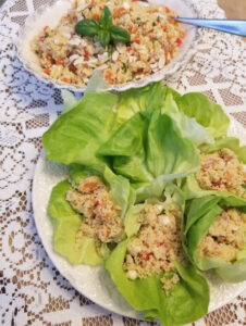 Fresh lettuce wraps filled with a colorful quinoa salad.