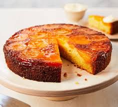 A round pineapple upside-down cake with one slice missing.