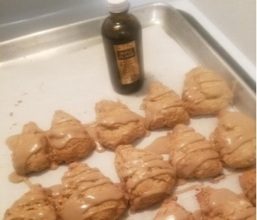 Baked star-shaped cookies drizzled with caramel on a tray.