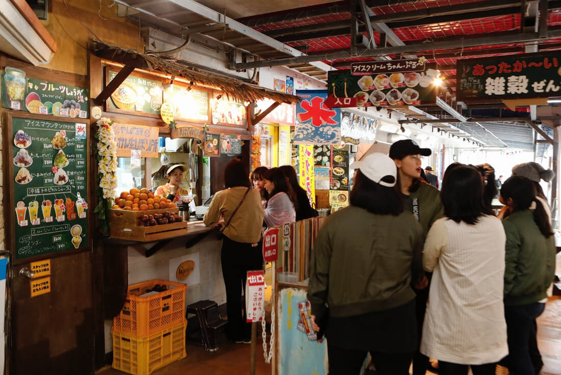 Busy indoor market with people shopping and socializing.