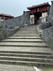Stone stairs leading up to a traditional building with red accents.