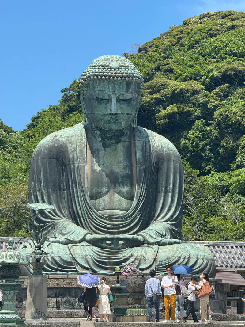 Large statue of Buddha seated in meditation outdoors.