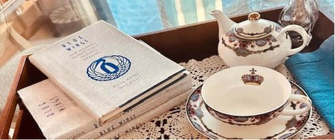 Vintage porcelain tea set with a floral pattern on a lace tablecloth.