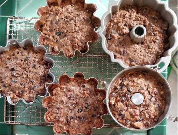 Four fluted cake pans filled with unbaked chocolate chip batter.