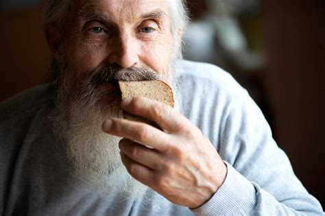 Elderly man enjoying the aroma of fresh bread.