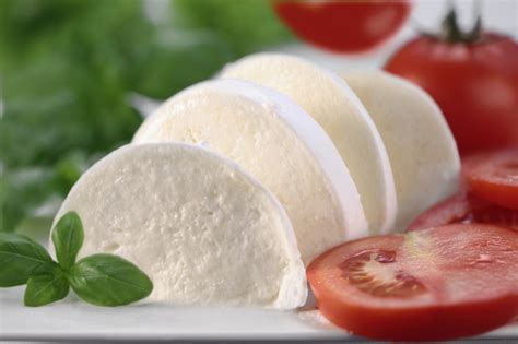 Sliced fresh mozzarella cheese with tomatoes and basil.
