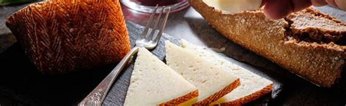 Close-up of triangular white sandwiches with a fork nearby.