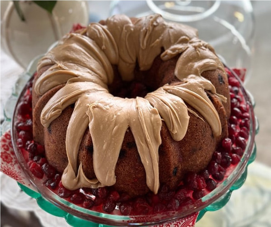 Bundt cake with creamy frosting and pomegranate seeds.
