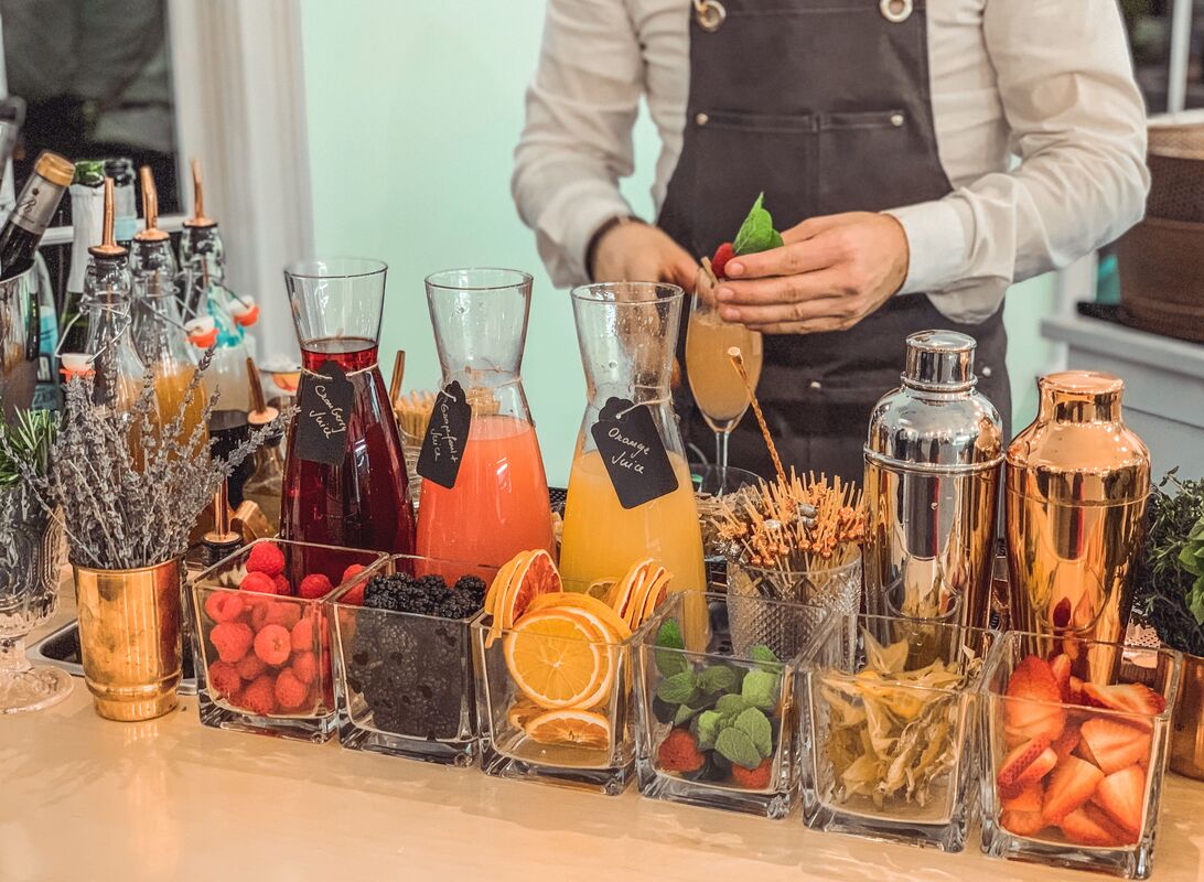 A bartender preparing cocktails with fresh fruits and herbs.