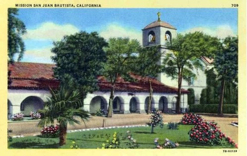 Historic Mission San Juan Bautista with gardens and arches in California.