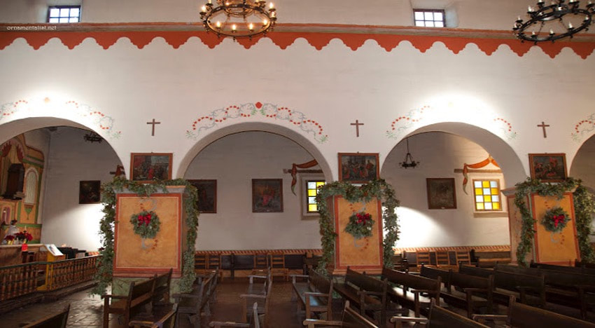 Interior of a historic church with wooden pews and decorative arches.