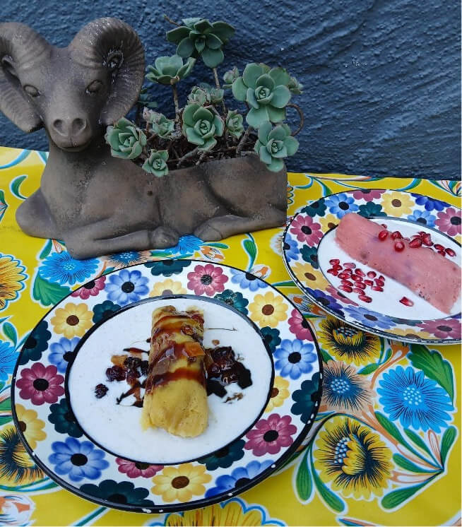 A plated dessert with a flower vase on a vibrant tablecloth.